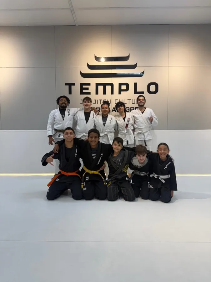 Turma juvenil da Templo posando no tatame, adolescentes de kimono branco e preto
